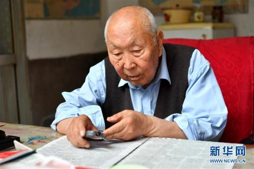 7月19日,郝郁民在家里看报纸。新华社记者 曹阳 摄 点击进入下一页
