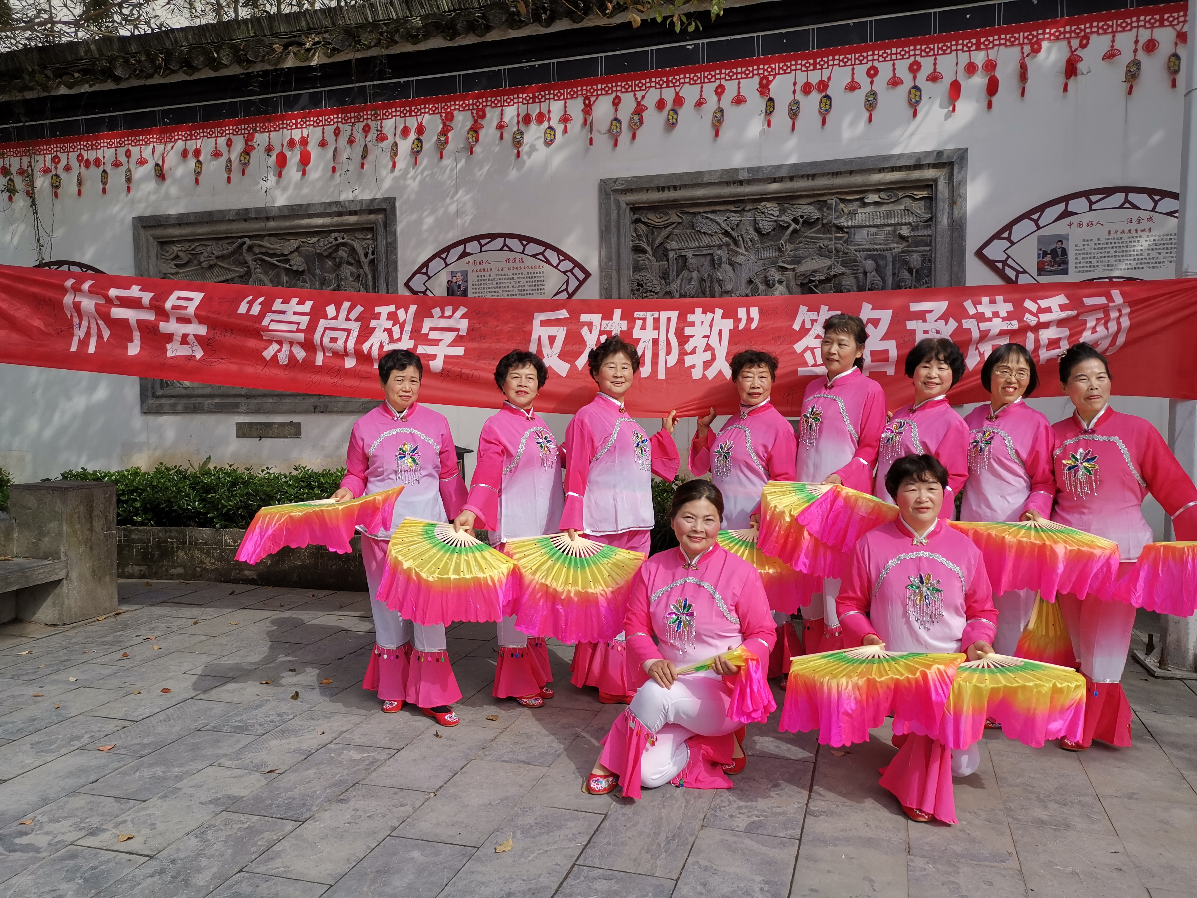休宁县“大妈反邪”志愿者队伍在“崇尚科学 反对邪教”横幅上签名承诺并合影留恋